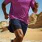 Person running in a desert landscape wearing a purple shirt and blue shorts (Blue)