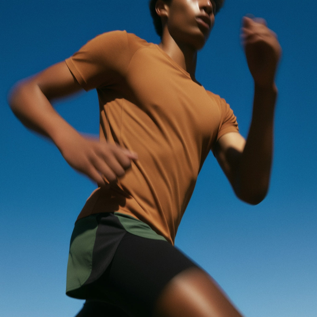 Person running outdoors with a clear blue sky background (Beige)