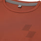 Close-up of a textured orange shirt with a brand tag (Orange)