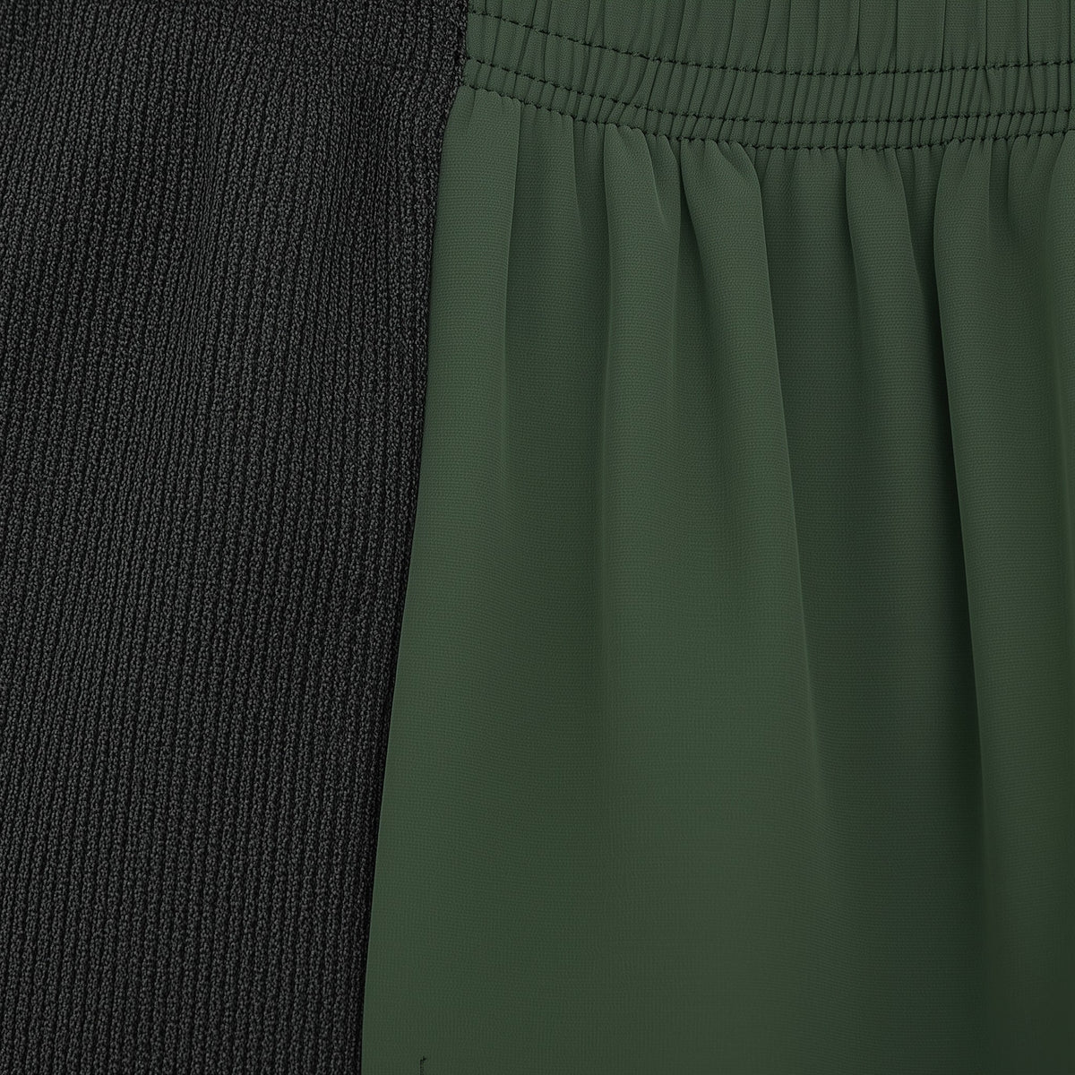 Close-up of a green fabric with a textured black section on the left. (Green)