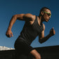 Athlete running outdoors with a clear blue sky (Green)